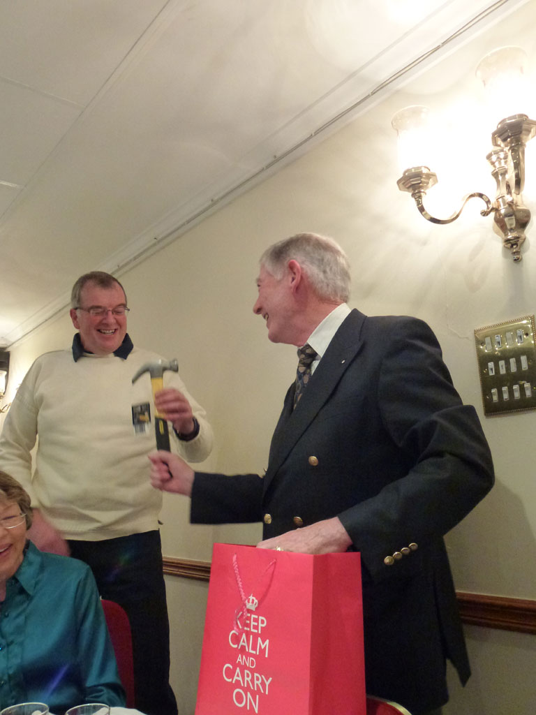 Mr Matthews presents the club’s ‘Master Builder’ with a new hammer (and a bottle of whisky) for his efforts